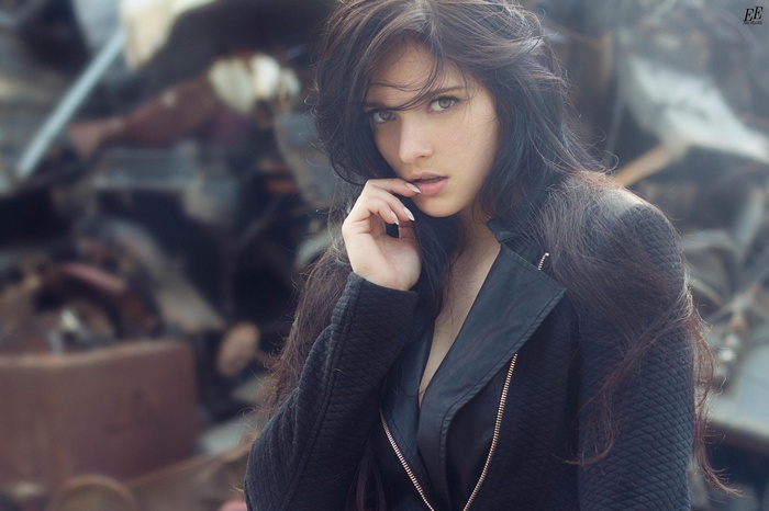Model with long brown hair and black clothing