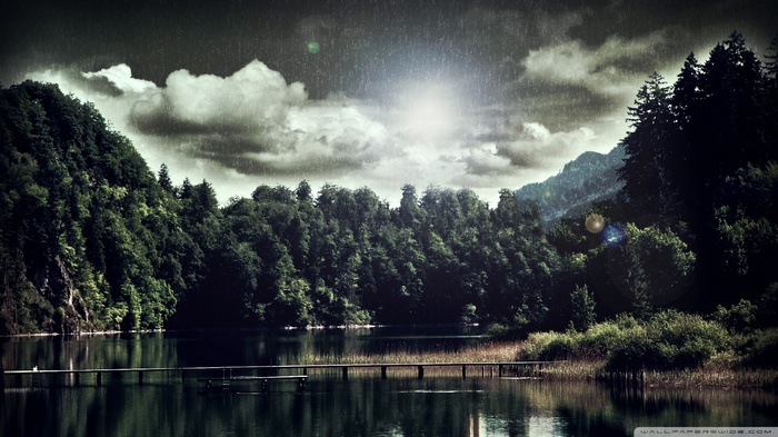 Rainy day over a lake with a wooden pier and forest