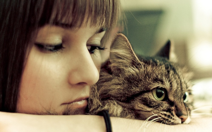 Woman resting her head on a cat