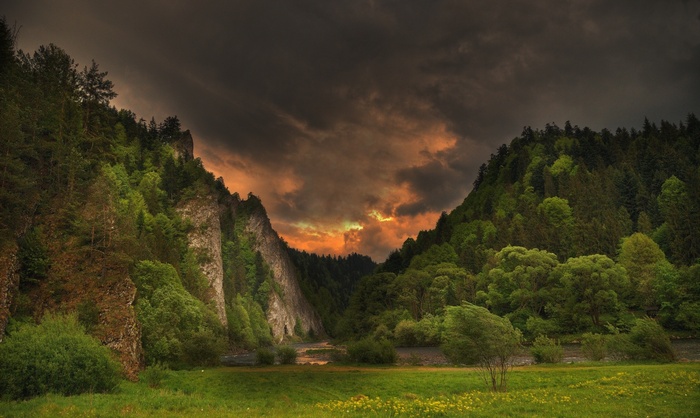Stormy sky over a forested river valley with cliffs
