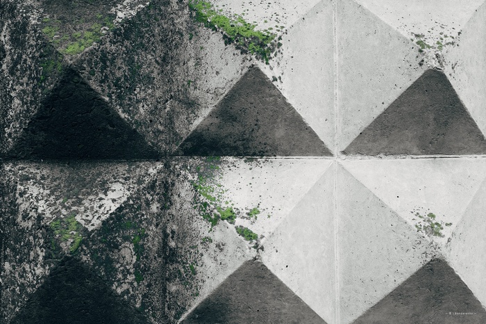 Concrete fence with geometric pattern and moss