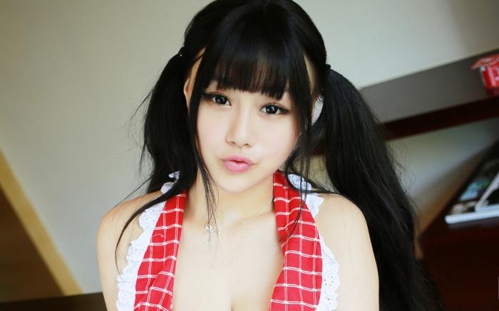 Asian woman with pigtails wearing a red and white apron