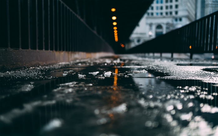 Ice and puddles on a wet road at night