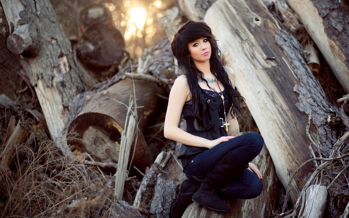 Linsey Potter posing among logs