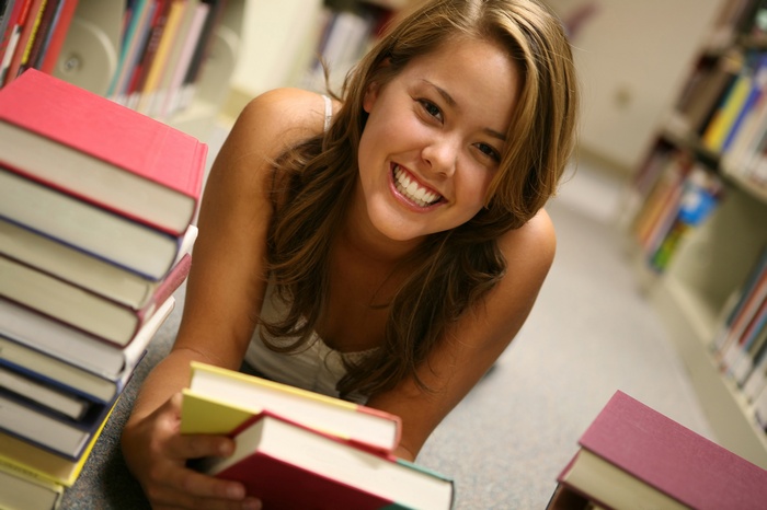 Young woman smiling in a library with books