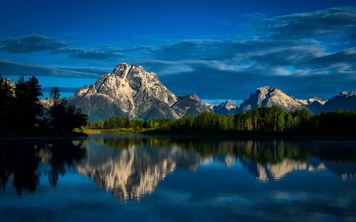Snow-capped mountains reflected in a calm lake