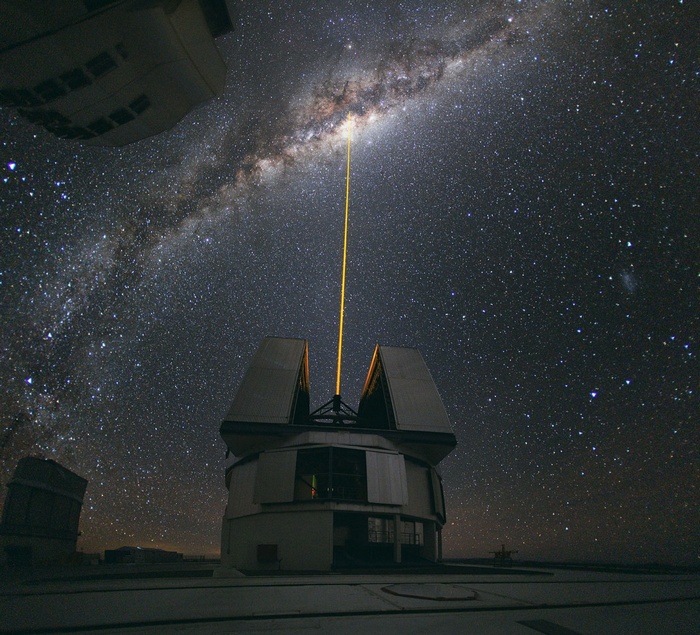 Observatory in Chile with laser beam pointing to the Milky Way