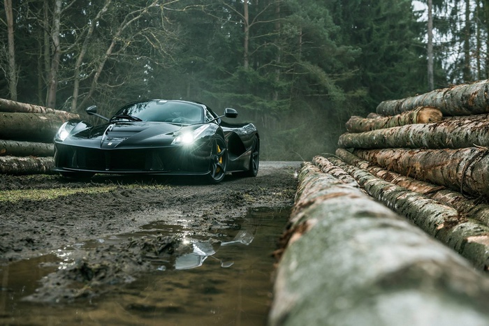 Black Ferrari LaFerrari on a muddy forest road