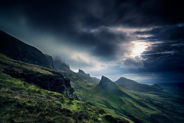 Dramatic clouds over green hills in Scotland