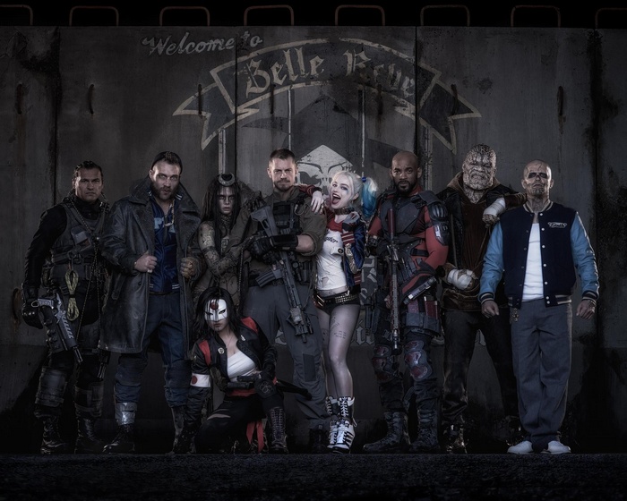 Suicide Squad characters posing in front of Belle Reve wall