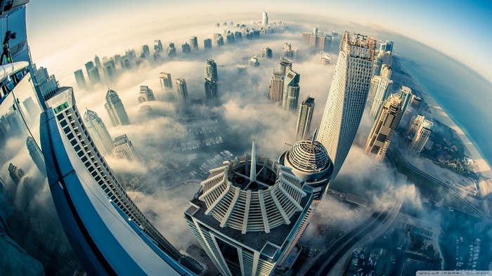 Dubai skyscrapers emerging from clouds with fisheye lens effect