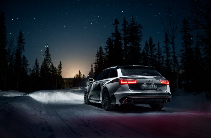 Audi RS6 Avant driving on a snowy road at night