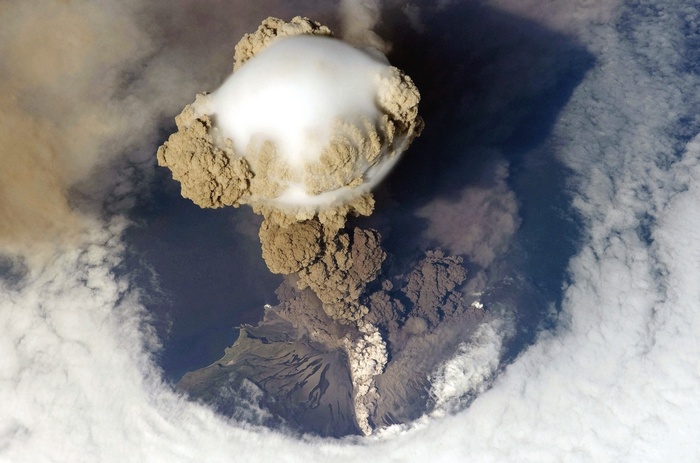 Aerial view of a volcano erupting ash and smoke