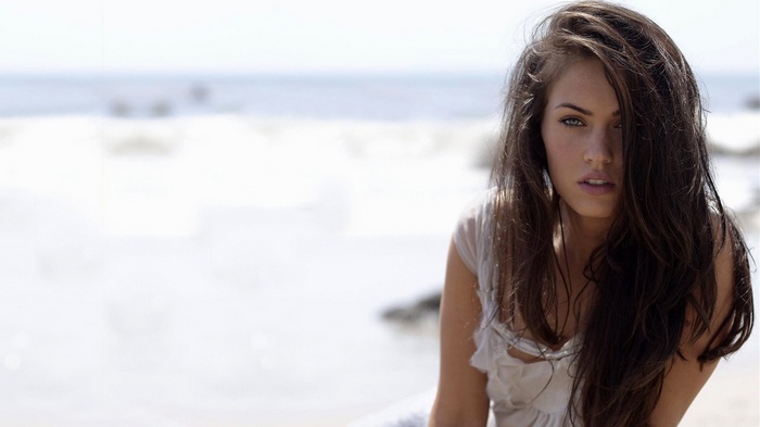Megan Fox on a beach with ocean in the background