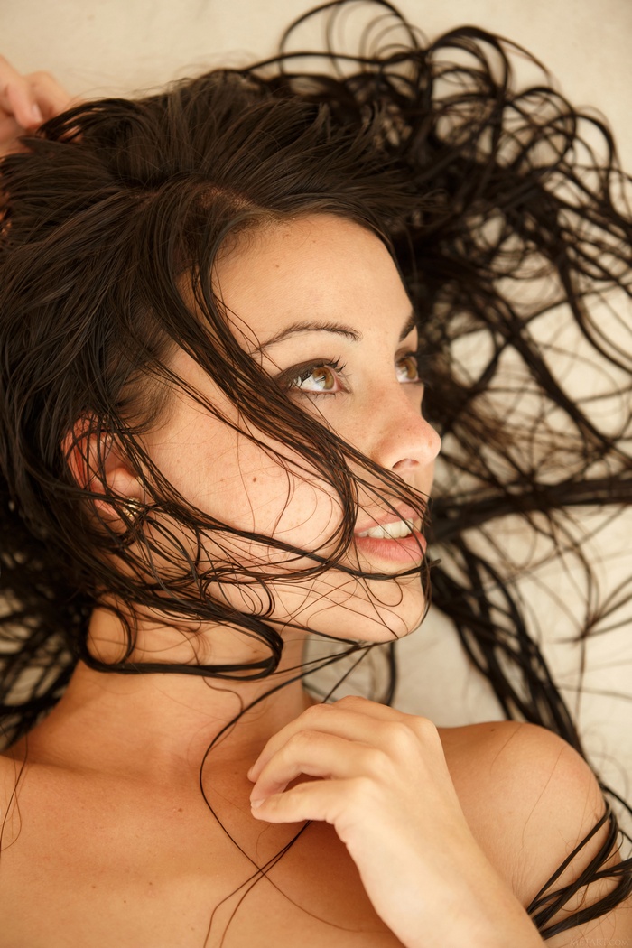 Woman with wet dark hair lying down