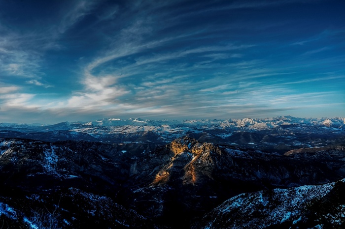Panoramic view of snow-capped mountains under a cloudy sky