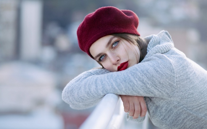 Woman with red lipstick and beret looking at viewer