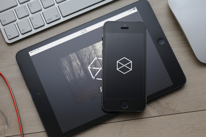 iPhone 5S and iPad displaying a logo and forest image