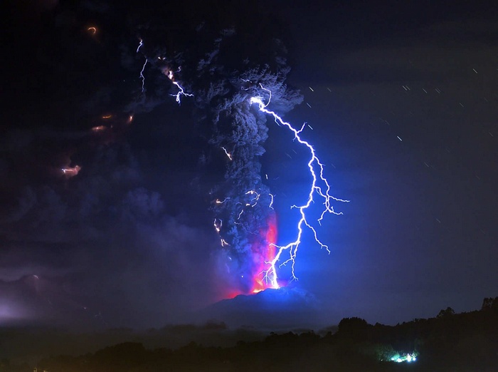 Volcano erupting with lightning strikes at night