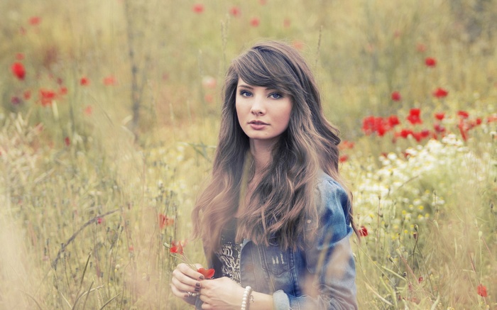 Woman in denim jacket in a field of poppies