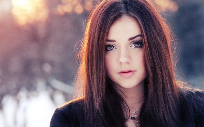 Woman with long brown hair looking at viewer