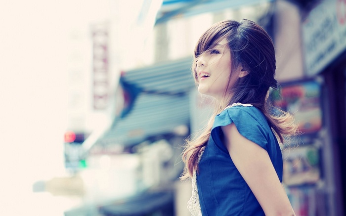 Asian woman in blue dress looking up