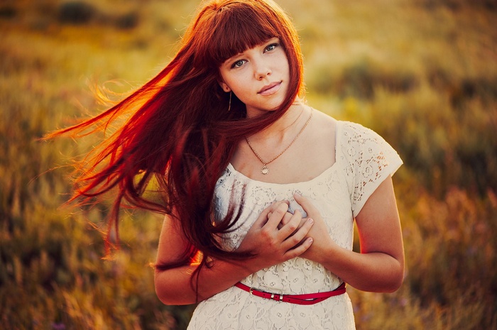 Redhead woman with long hair in a white dress
