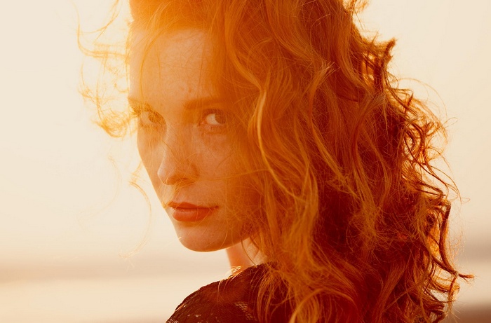 Portrait of Ann Nevreva with red hair in sunlight