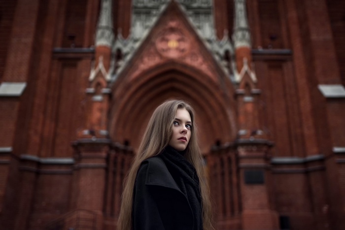 Ekaterina Kuznetsova in a black coat in front of a building