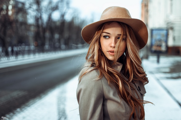 Woman in hat and trench coat in winter