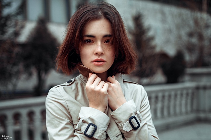 Woman in trench coat looking at viewer