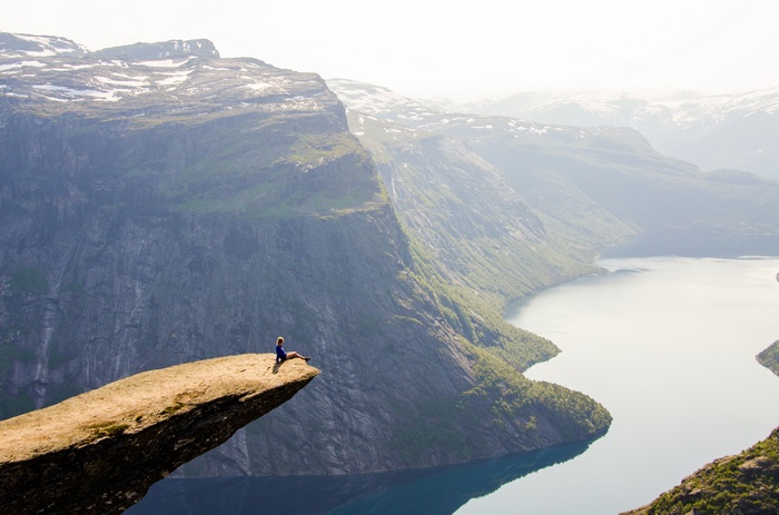 Person sitting on Trolltunga rock in Norway