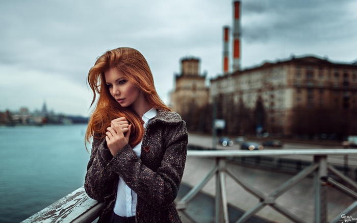 Redhead woman with long hair wearing a coat outdoors