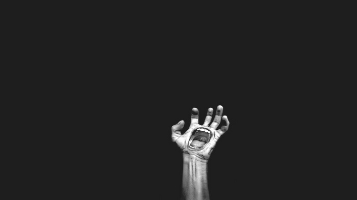 Horror artwork of a screaming hand against a black background