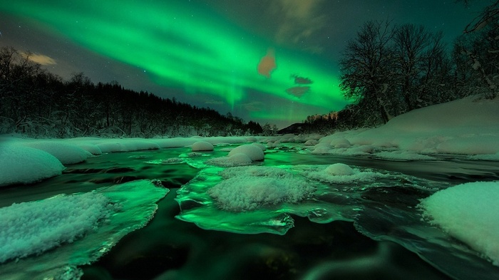 Aurora Borealis over a frozen river in winter