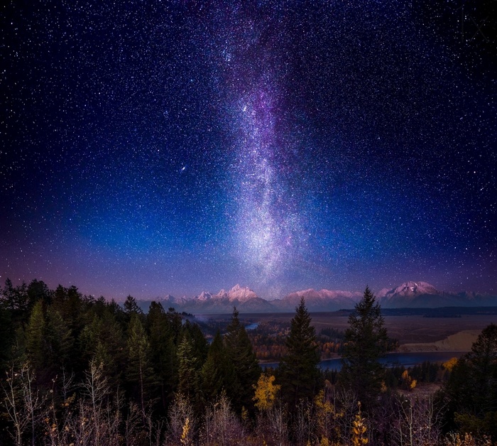 Milky Way over snowy mountains and forest