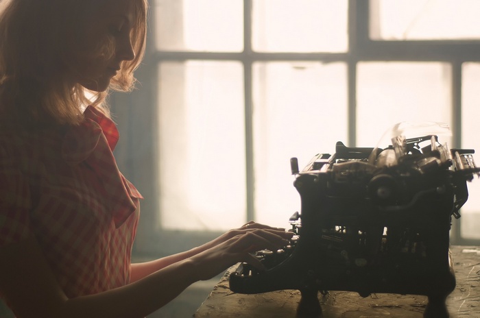 Woman typing on a vintage typewriter