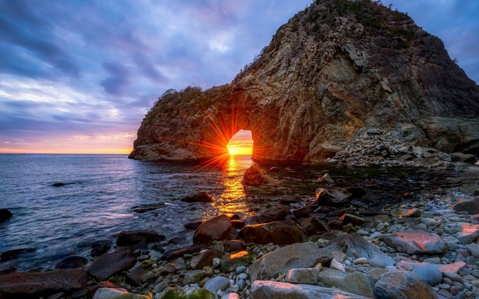 Sunset through a rock arch in Japan