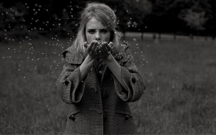 Cara Delevingne blowing glitter in a field