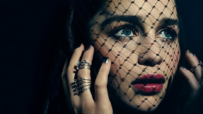 Emilia Clarke behind a black veil