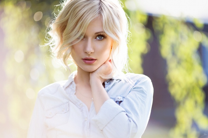 Blonde woman with blue eyes looking at viewer outdoors