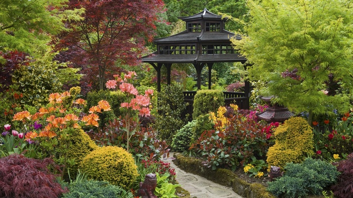 A beautiful garden with a gazebo and colorful flowers