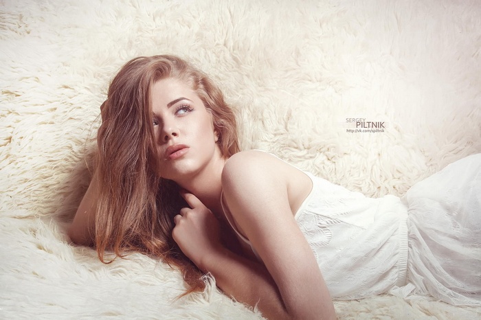 Alexandra Danilova in a white dress on a fluffy surface