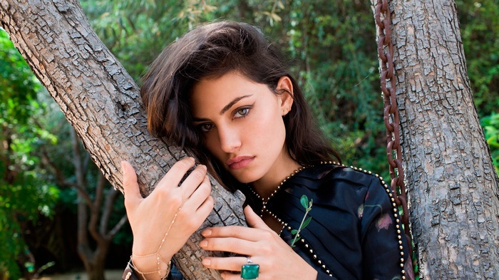 Phoebe Tonkin leans against a tree trunk