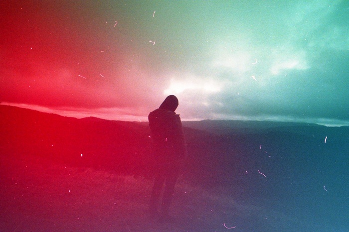 Person standing on a hill overlooking mountains