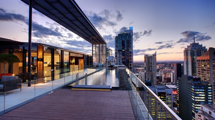 Rooftop swimming pool overlooking a cityscape at dusk