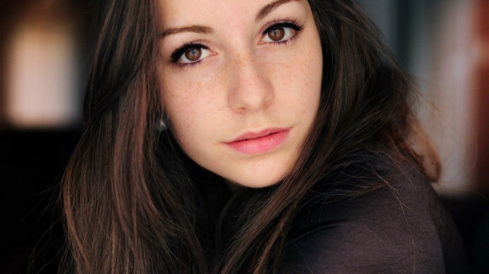 Close-up portrait of a young woman with freckles