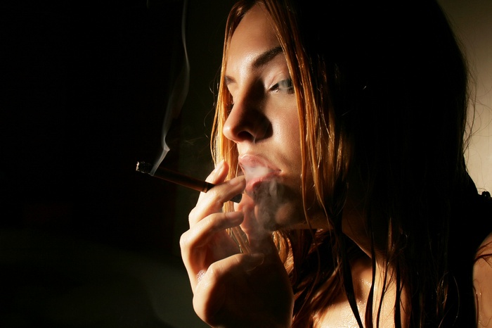Woman smoking a cigarette in the dark