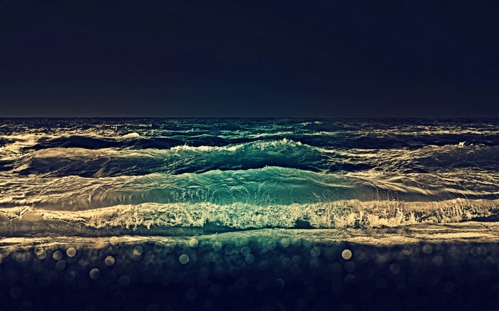 Dark ocean waves with bokeh lights