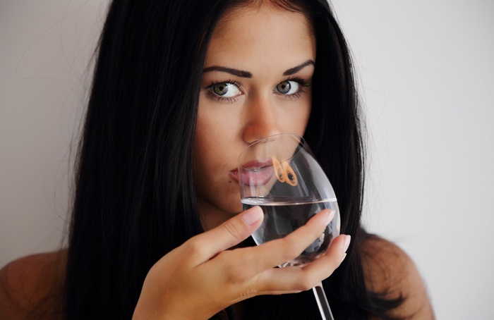 Brunette woman drinking water from a glass